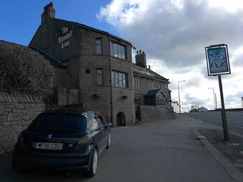 Road by building against sky in city