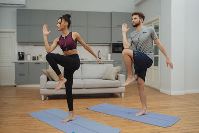 Full length of young woman exercising in gym