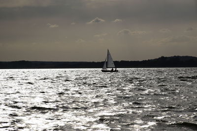 Sailboat sailing on sea against sky