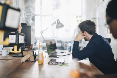 Male computer programmer working at desk in creative office