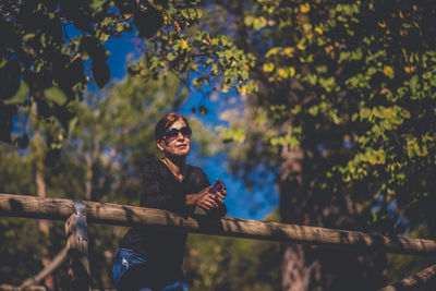 Woman standing by tree