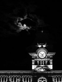 Low angle view of clock tower against sky at night