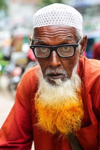 Portrait of senior man with dyed bear wearing eyeglasses