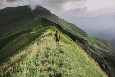 Rear view of man walking on mountain
