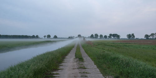 Scenic view of field against sky during foggy weather