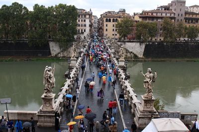 High angle view of people walking on bridge over river during rainy season