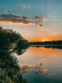 Scenic view of lake against sky at sunrise 