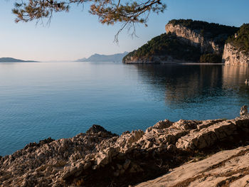 Scenic view of sea and mountains against sky