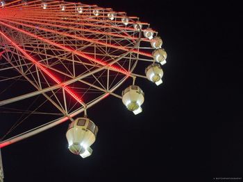 Low angle view of illuminated ferris wheel against sky at night