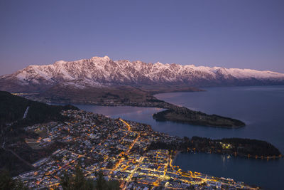 Aerial view of illuminated cityscape by river at night