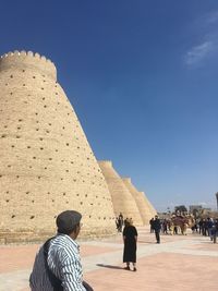 Rear view of people walking against sky