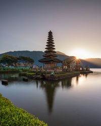 Temple by building against sky during sunset