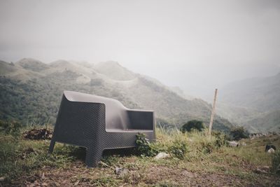 Chair on mountain against clear sky