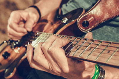 Midsection of man playing guitar