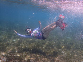 Full length of young woman swimming in sea