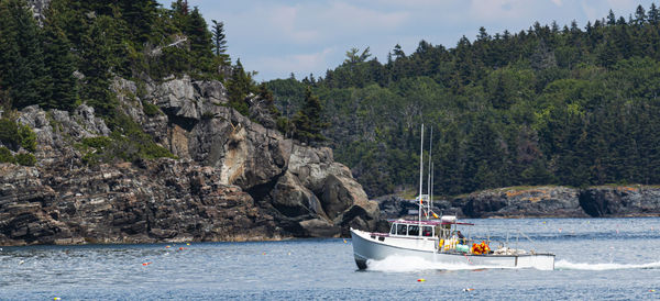 A lobster boat heading back from sea passing the porcupine islands in frenchman bay bar harbor maine