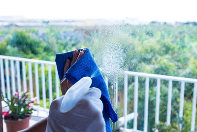 Midsection of person holding umbrella on balcony