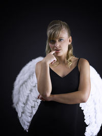 Portrait of a beautiful young woman over black background