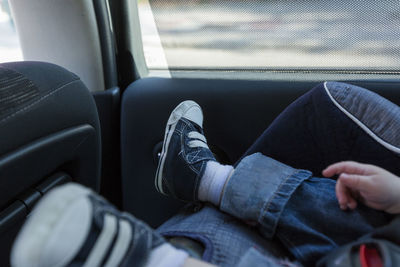 Low section of baby sitting on car seat