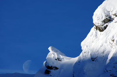 Scenic view of snowcapped mountains against clear blue sky