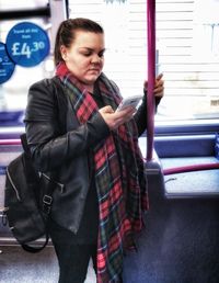 Young woman using mobile phone at bus