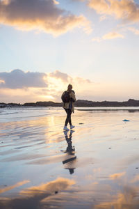 Rear view of man at beach against sky