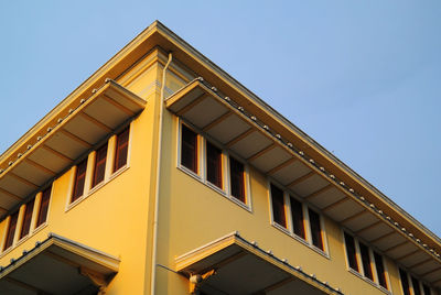Low angle view of yellow building against clear sky