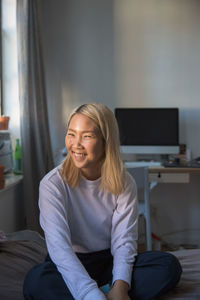 Portrait of smiling woman sitting at home