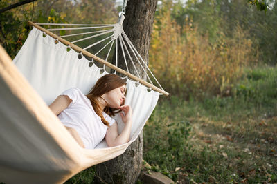 Midsection of woman relaxing on hammock