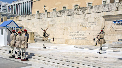 People walking on sidewalk by building