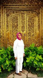 Portrait of woman standing against plants