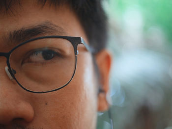 Close-up of man wearing eyeglasses looking away