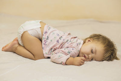 Portrait of cute baby boy lying on bed at home