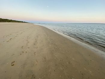 Scenic view of beach against clear sky during sunset