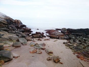 Rocks on beach against sky