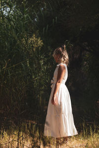 Woman standing by plants on field