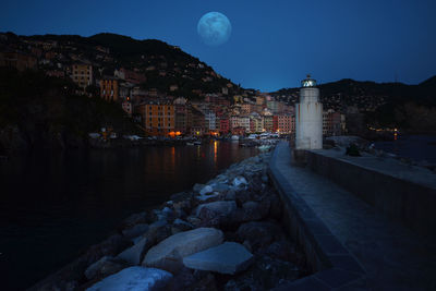 Incredible full moon in camogli in front of the lighthouse