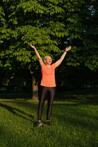 Full length of woman exercising on field