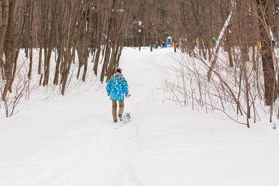 Rear view of person on snow covered field