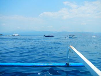 Sailboats sailing in sea against sky