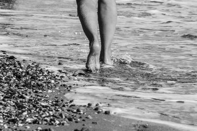 Low section of man standing on beach