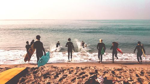 People enjoying on beach against sky