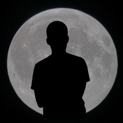 Silhouette of man against moon in sky