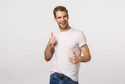 Portrait of young man standing against white background