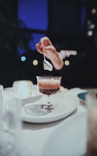 Midsection of woman holding drink on table