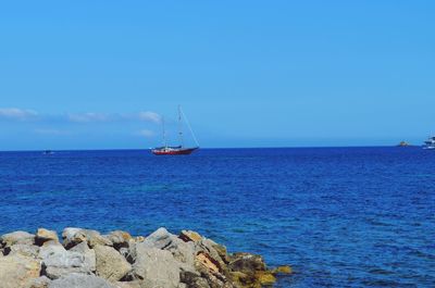 Sailboat on sea against blue sky