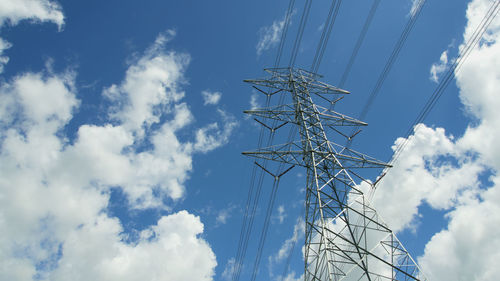 Low angle view of electricity pylon against blue sky