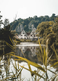 Houses by lake and buildings against clear sky