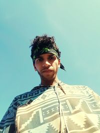 Low angle portrait of man against clear sky