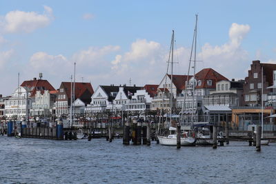 Sailboats in sea against buildings in city